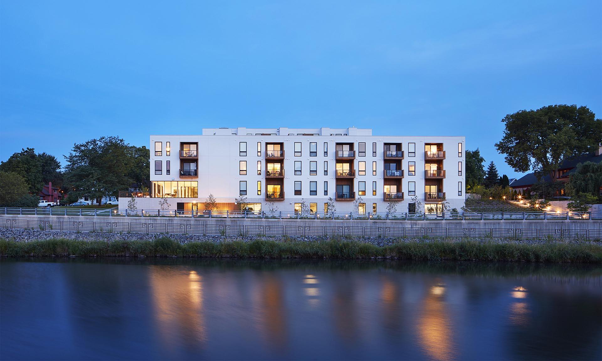 Lofts at Mayo Park exterior with lights reflecting in water